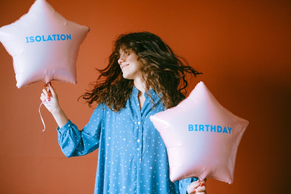 Woman in a blue dress celebrates isolation birthday with star-shaped balloons.