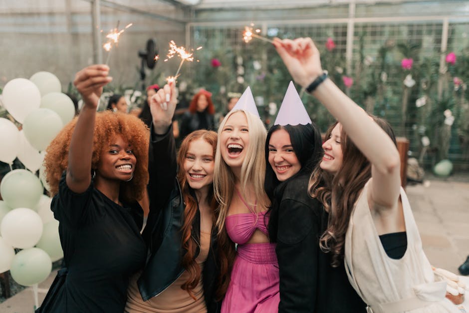 Group of young women celebrating with party hats and sparklers indoors, capturing lively birthday moments.
